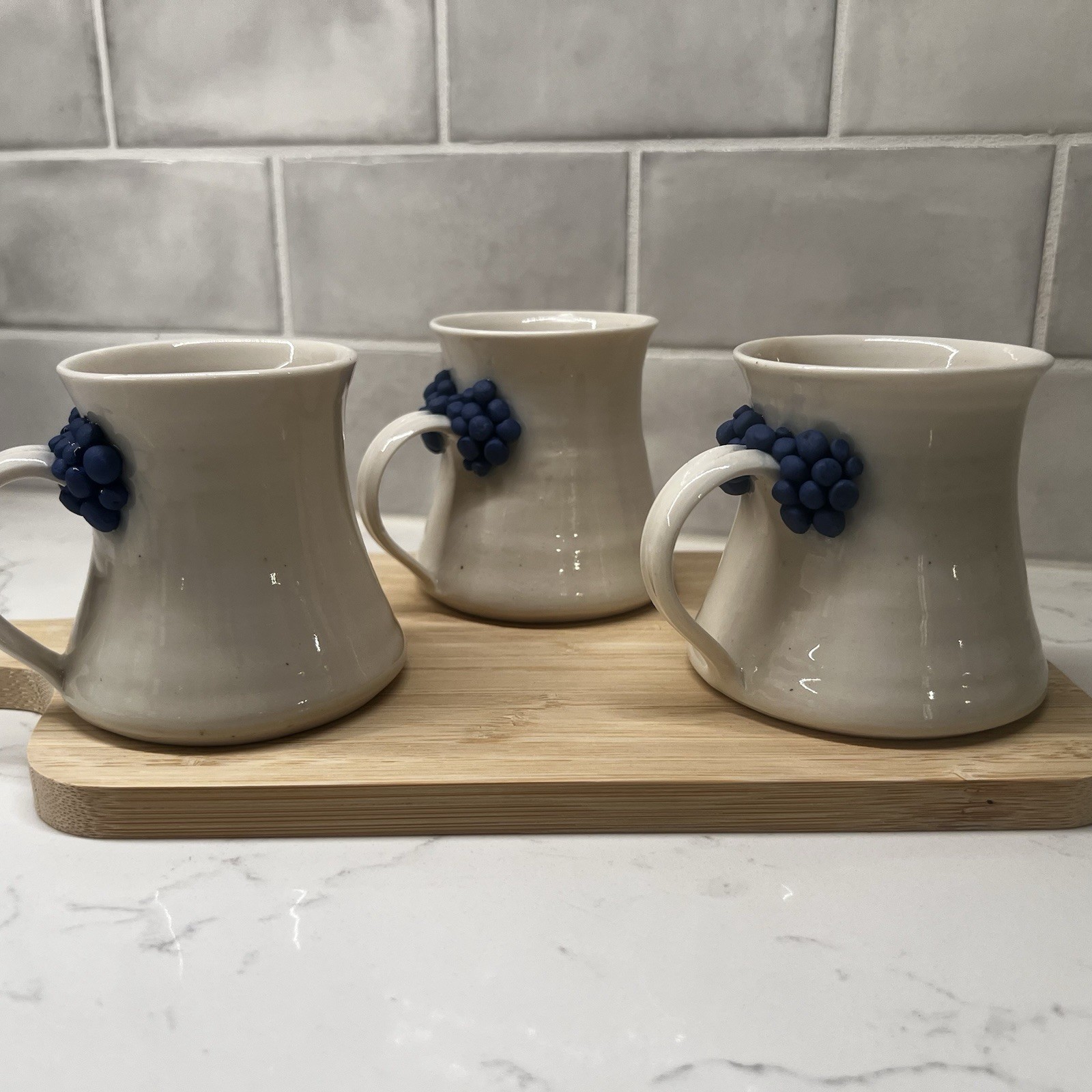 3 Handmade Pottery Mugs with blue grape design around handle, signed by artist