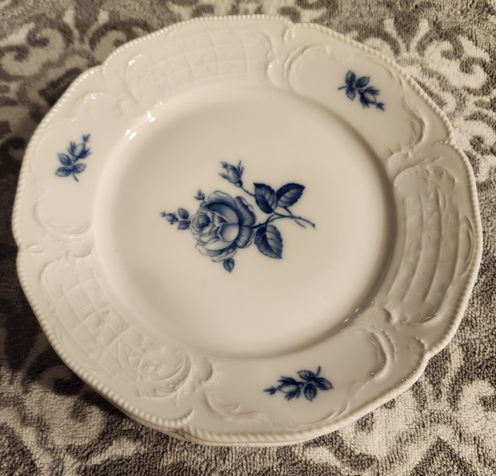 A set of 6 Rosenthal Sanssouci Blue Rose porcelain plates with embossed rims.