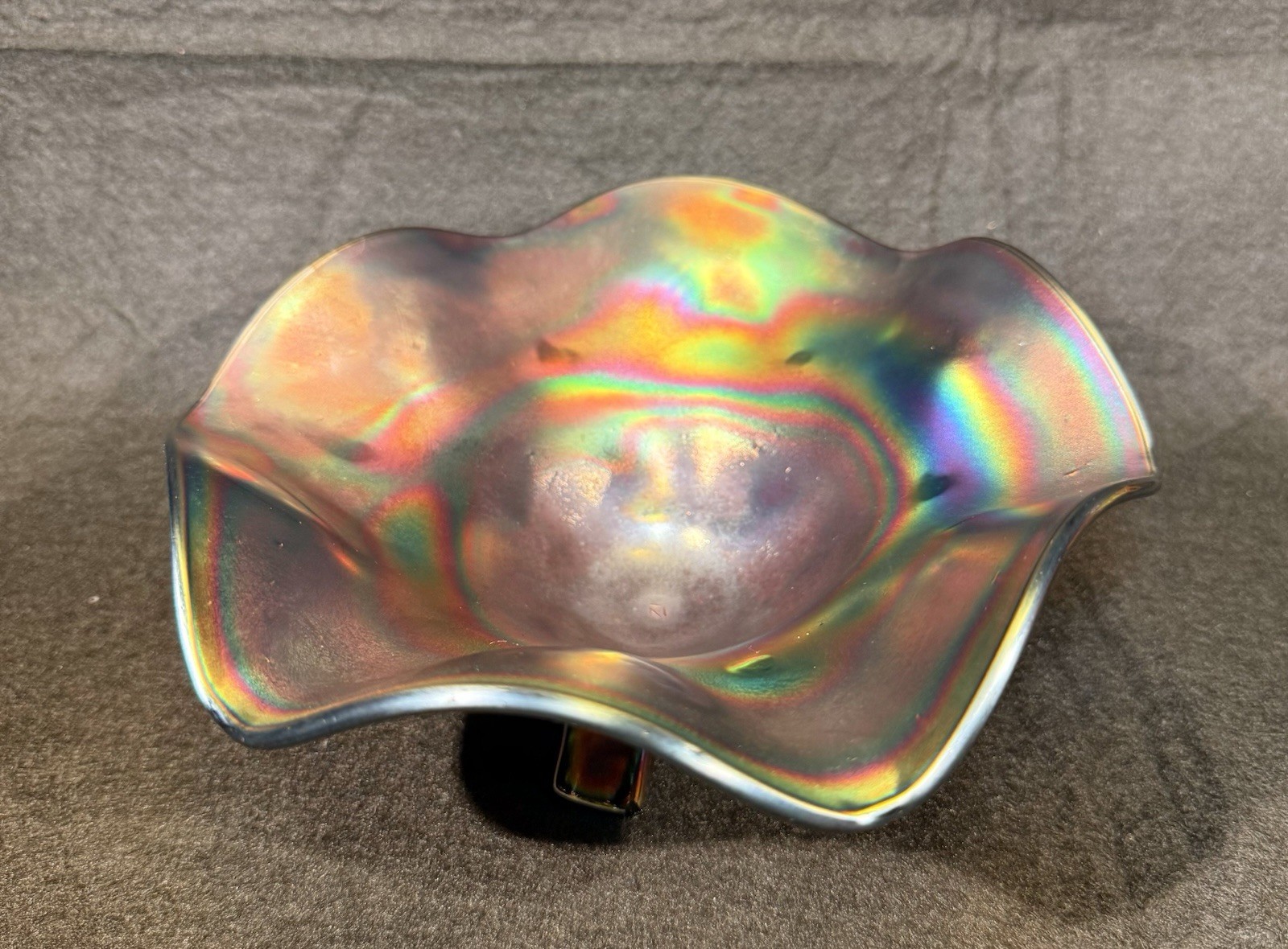 Carnival glass ruffled bowl with three-toed base, likely by Northwood