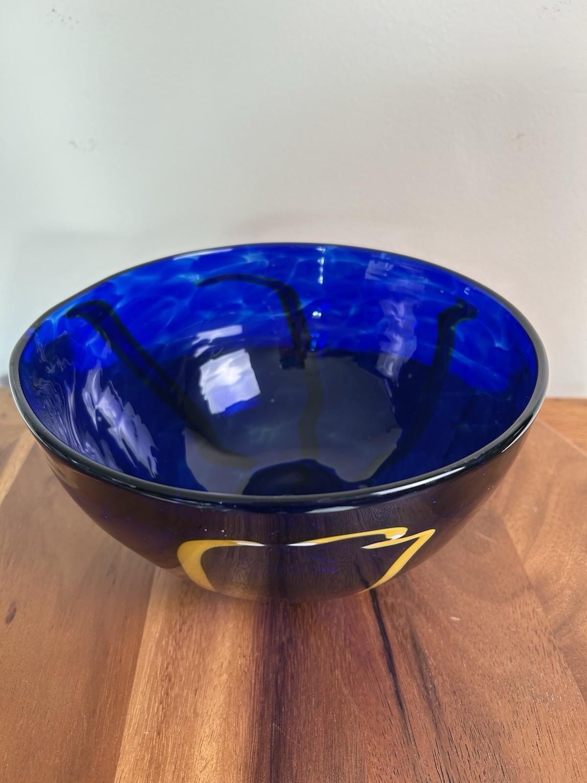 Cobalt blue art glass bowl with yellow and white design