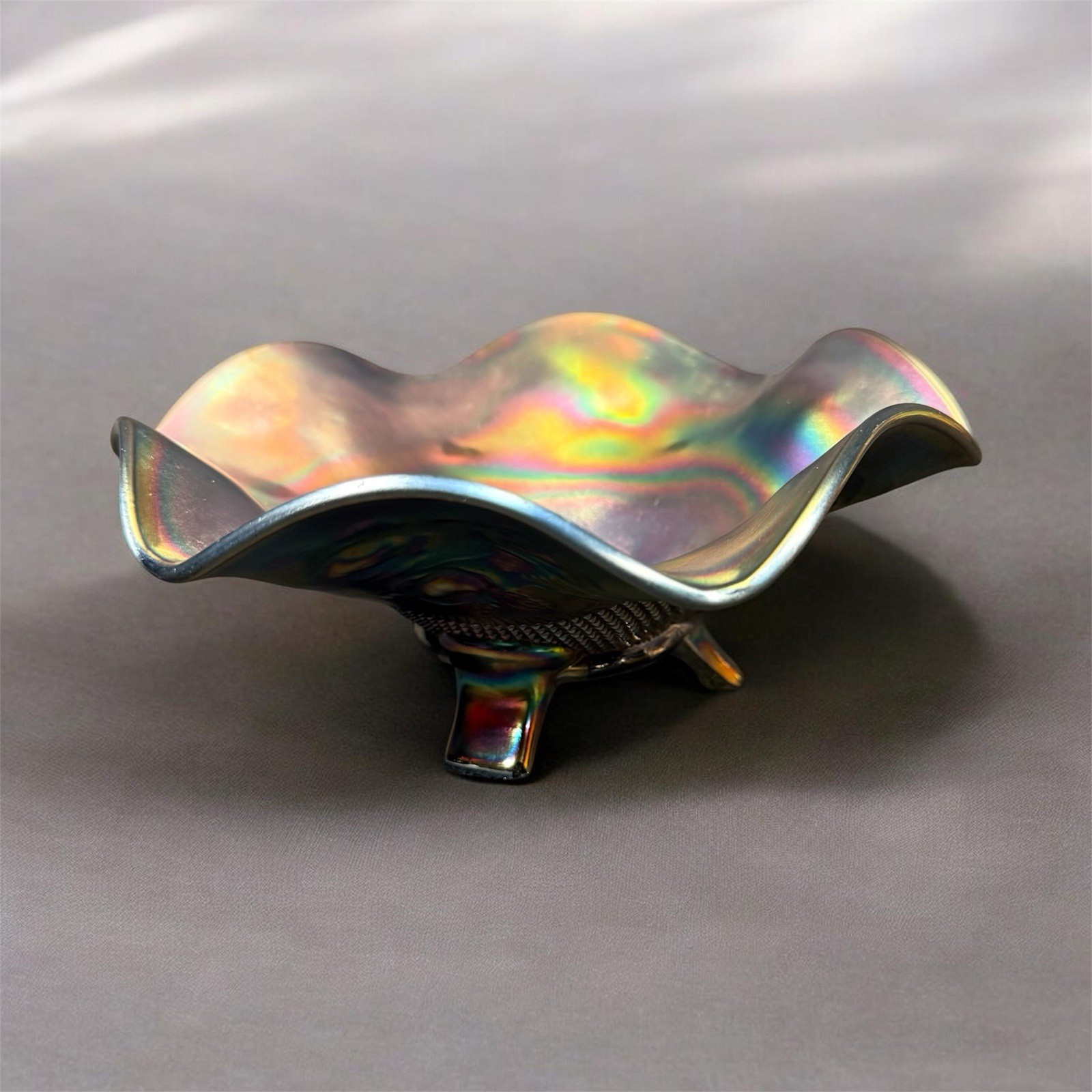 Carnival glass ruffled bowl with three-toed base, likely by Northwood
