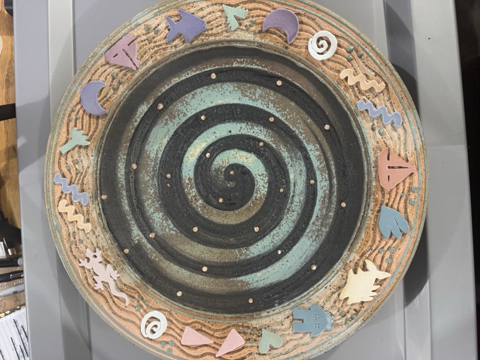 handmade ceramic platter featuring a central spiral design and decorative border