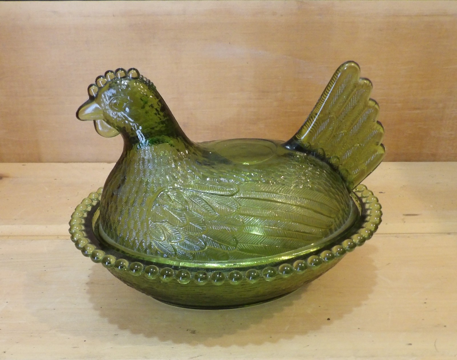 1 Indiana Glass Olive Green Hen on a Nest. 7″L x 5½”W x 5¼”H. There is one Chip