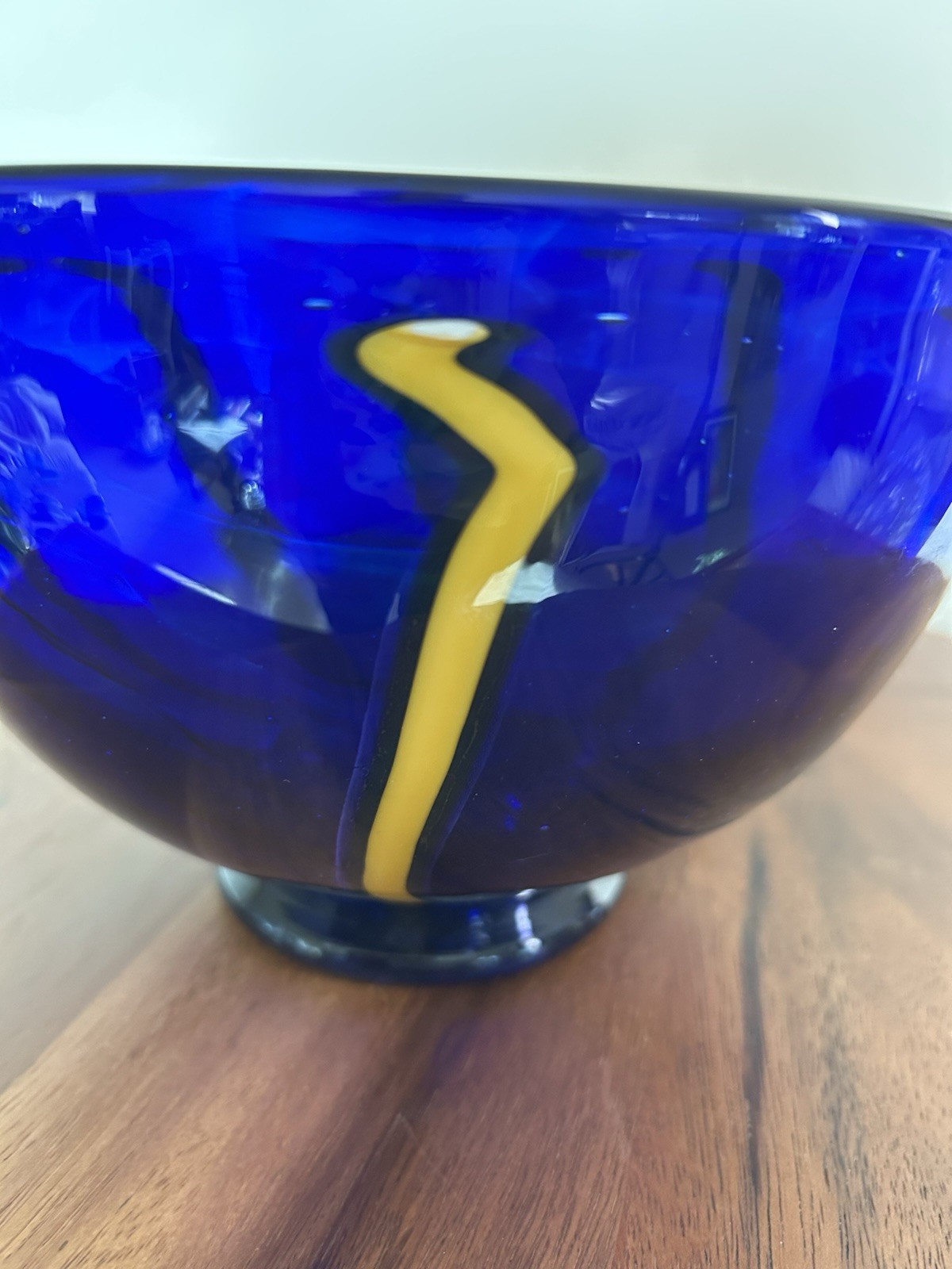 Cobalt blue art glass bowl with yellow and white design
