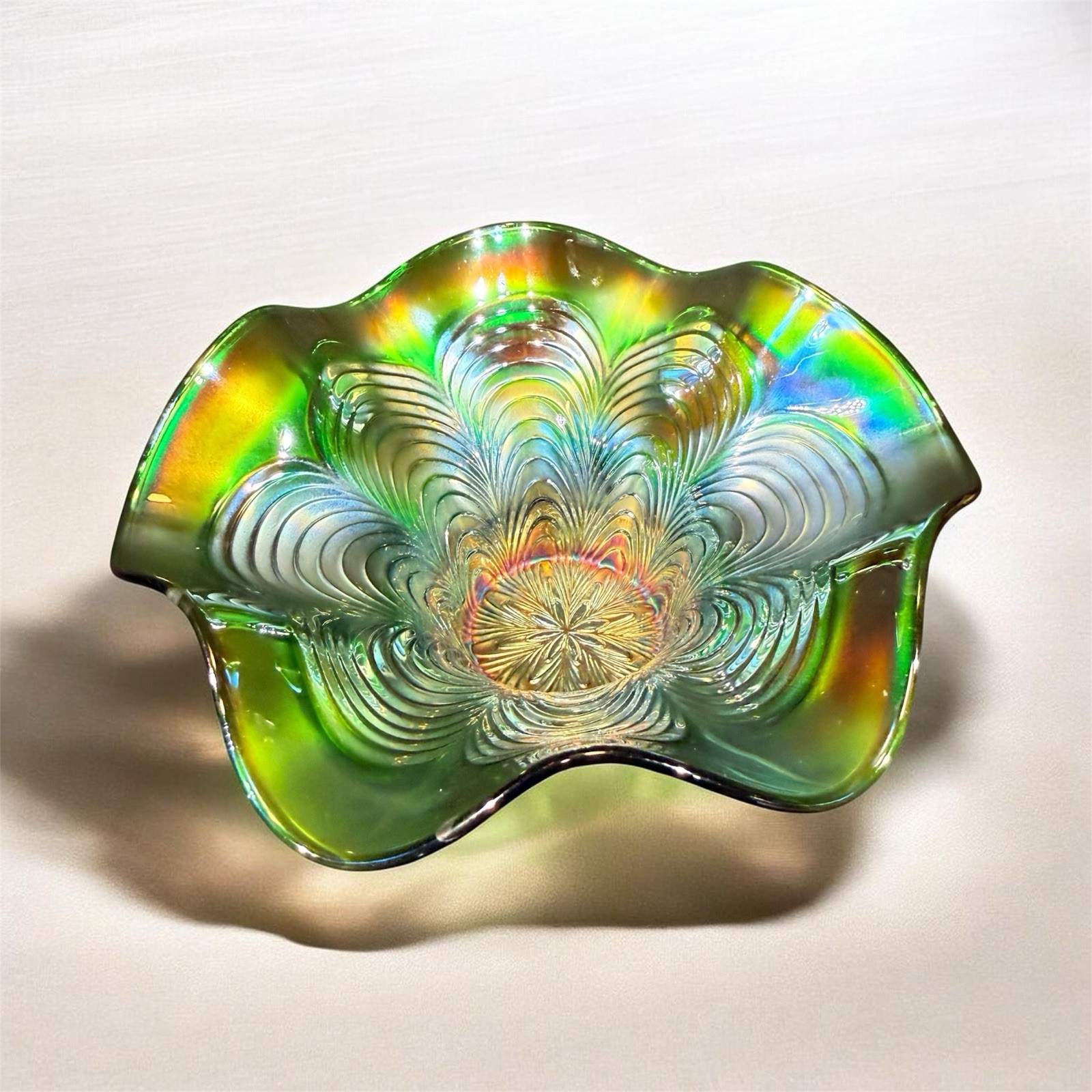 Green carnival glass ruffled bowl with ‘Stippled Rays’ pattern by Fenton