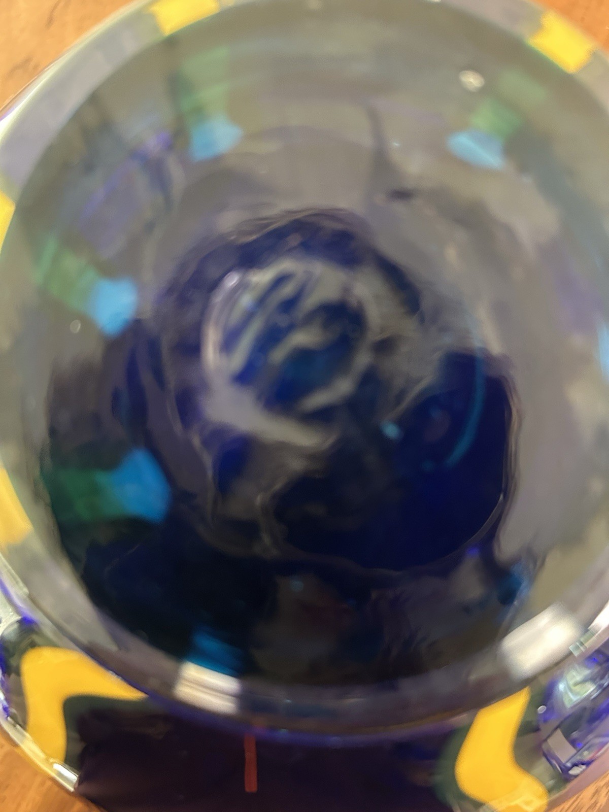 Cobalt blue art glass bowl with yellow and white design
