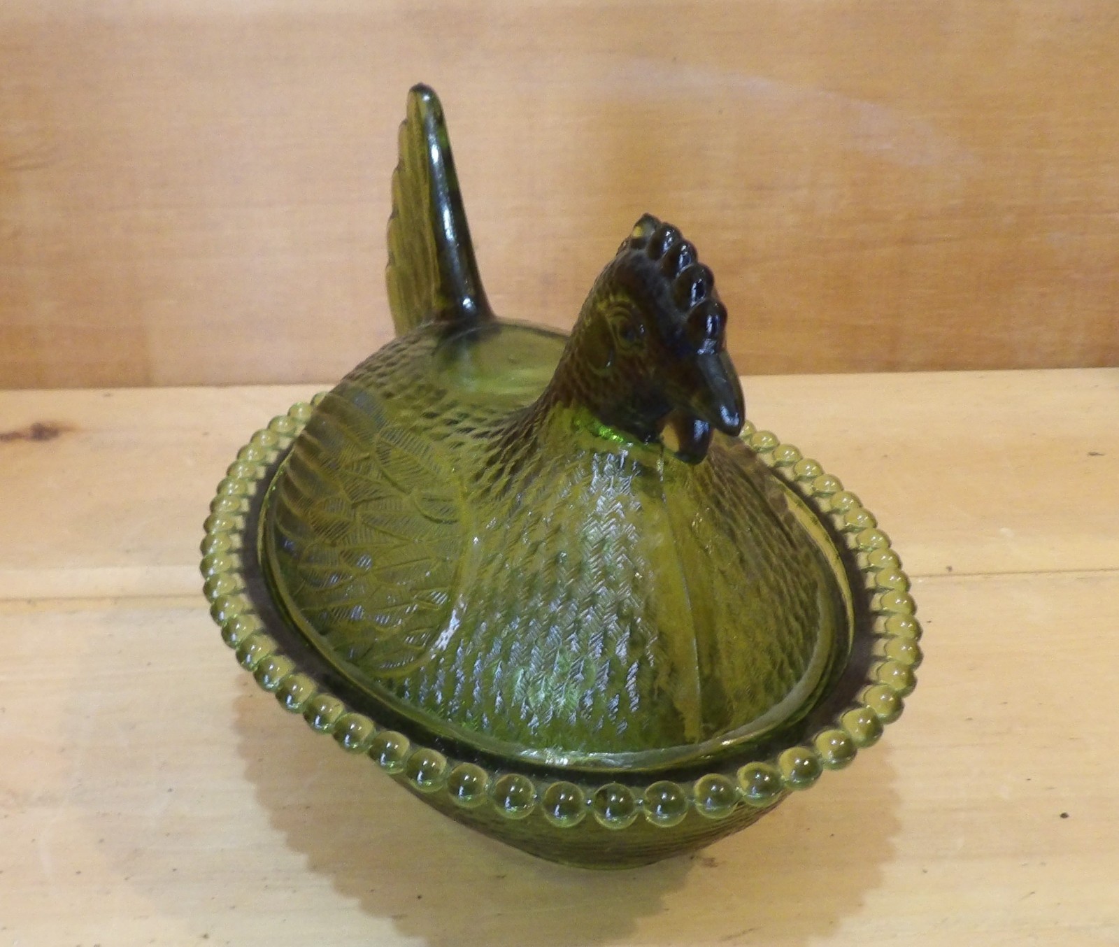 1 Indiana Glass Olive Green Hen on a Nest. 7″L x 5½”W x 5¼”H. There is one Chip