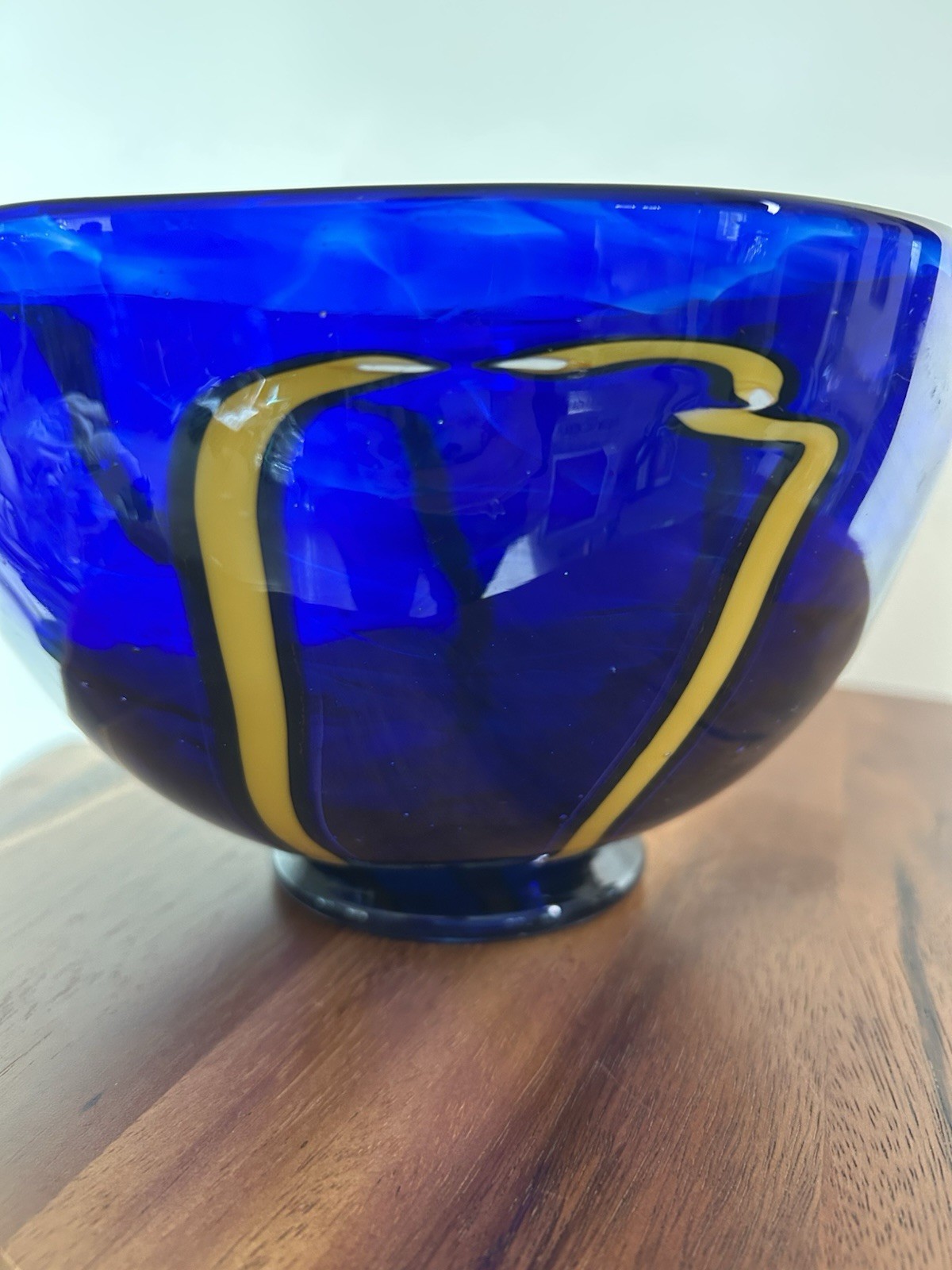Cobalt blue art glass bowl with yellow and white design