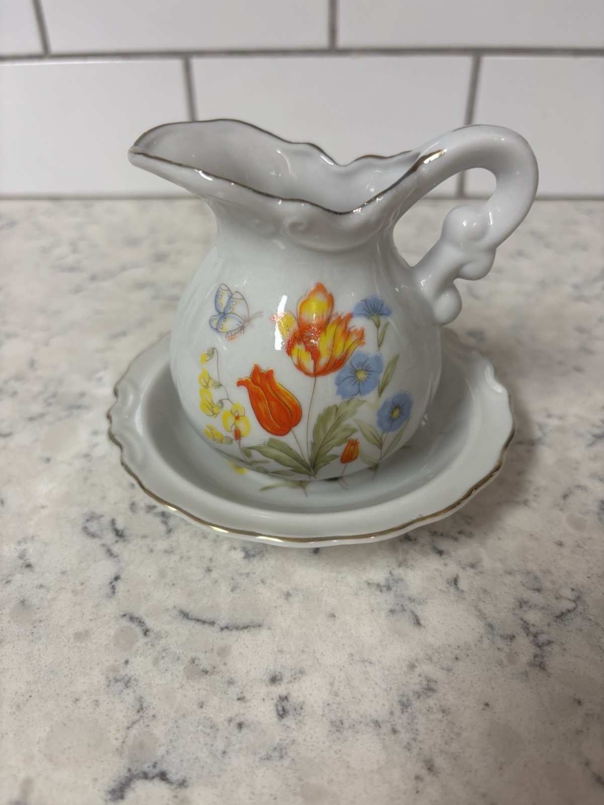 VTG porcelain creamer and saucer set with floral and butterfly. Made In Japan.
