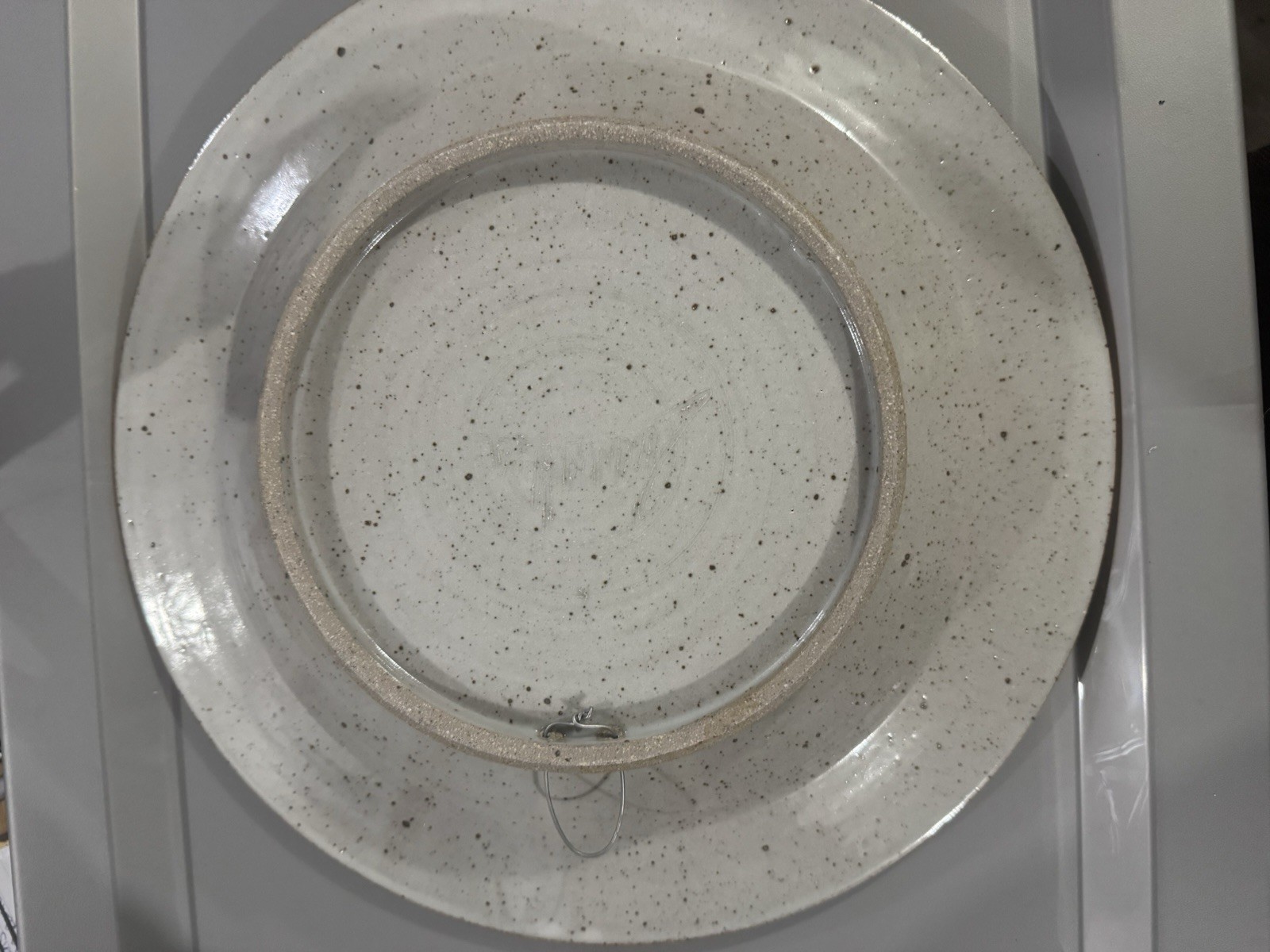 handmade ceramic platter featuring a central spiral design and decorative border