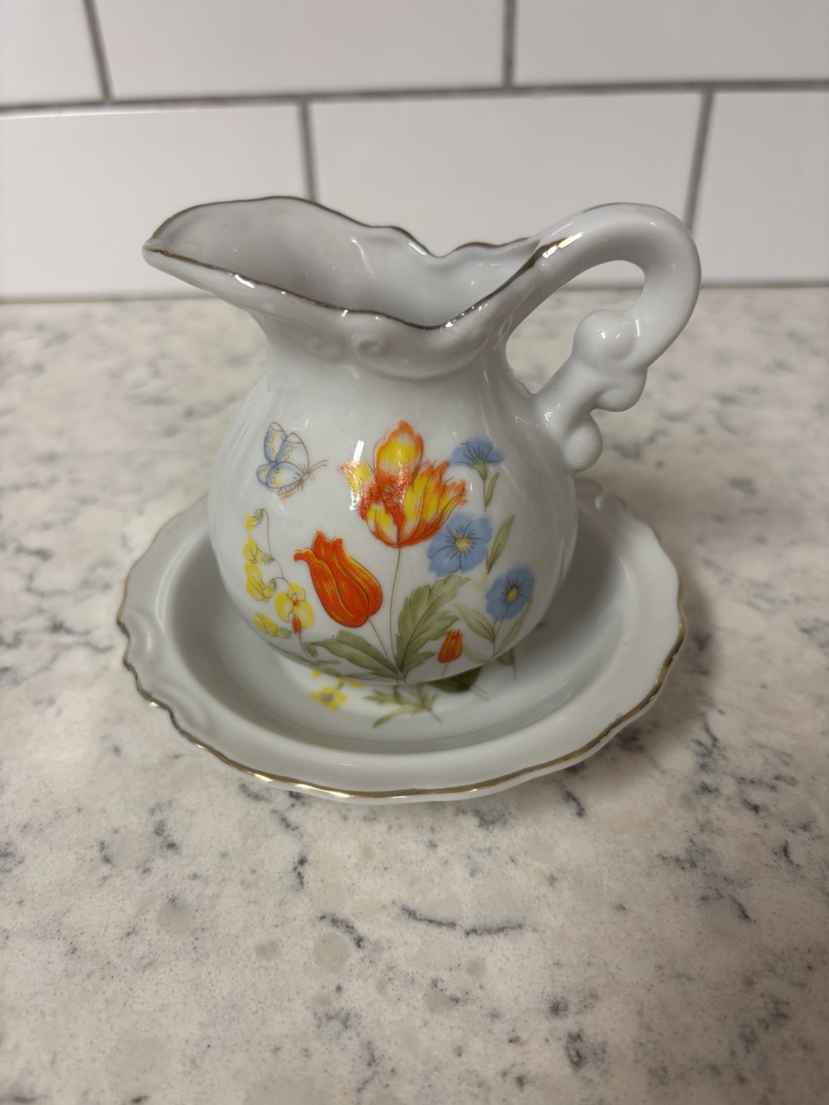 VTG porcelain creamer and saucer set with floral and butterfly. Made In Japan.