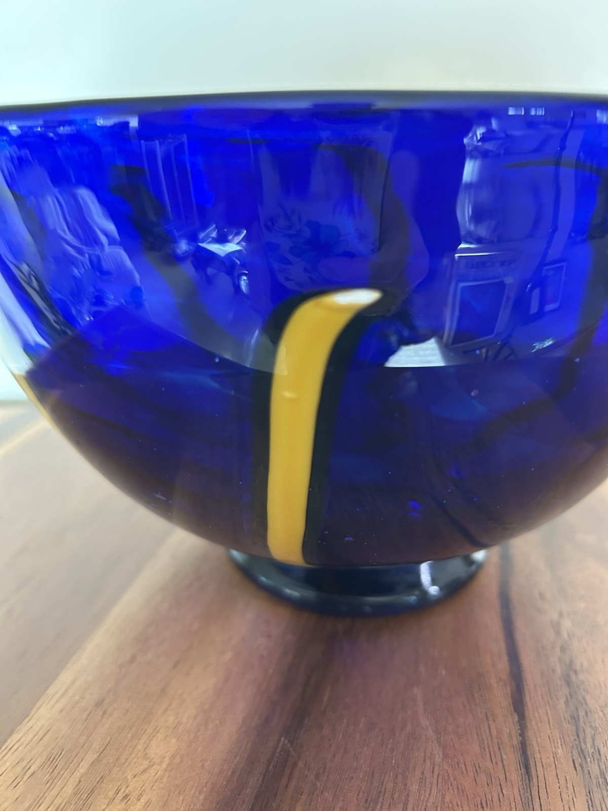 Cobalt blue art glass bowl with yellow and white design
