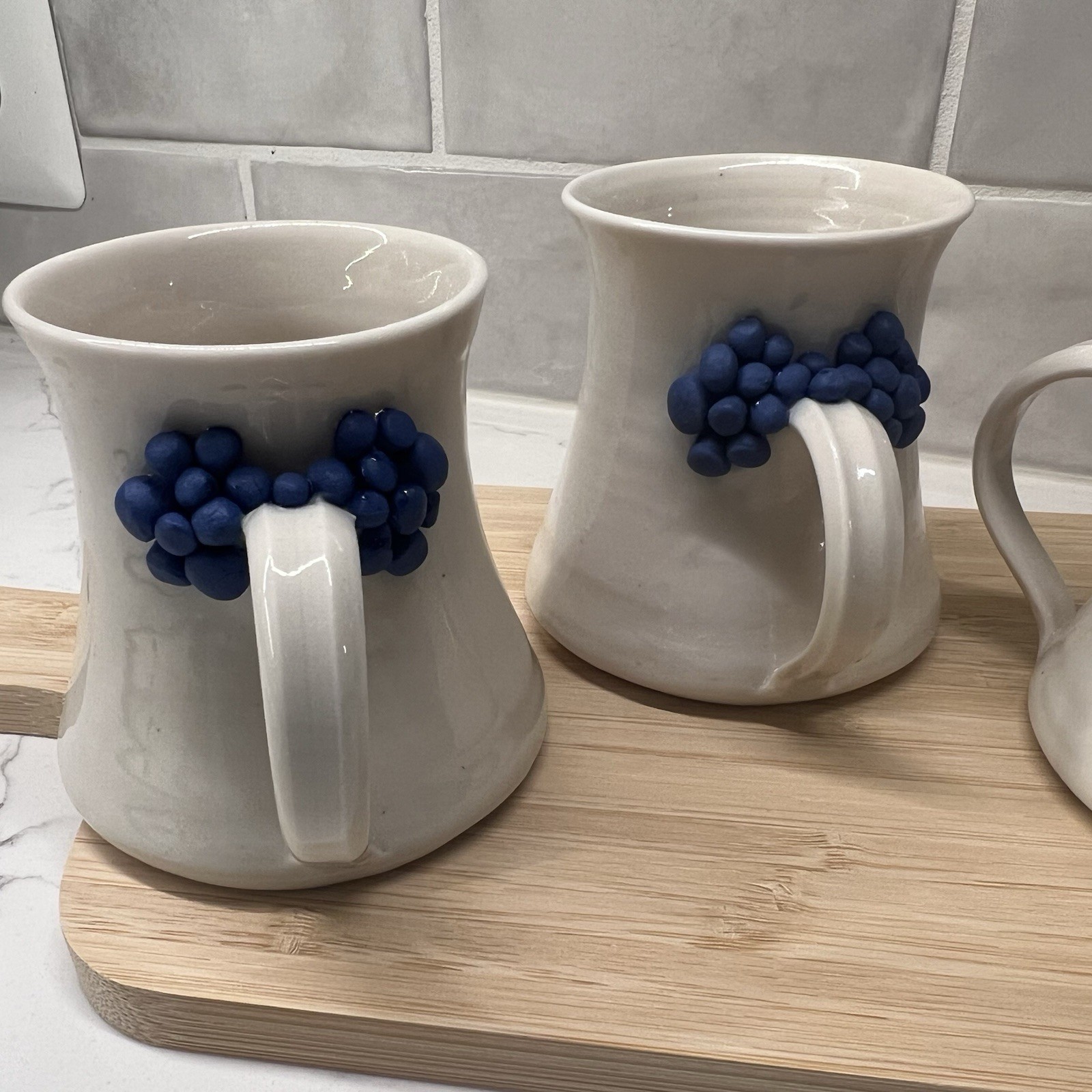 3 Handmade Pottery Mugs with blue grape design around handle, signed by artist
