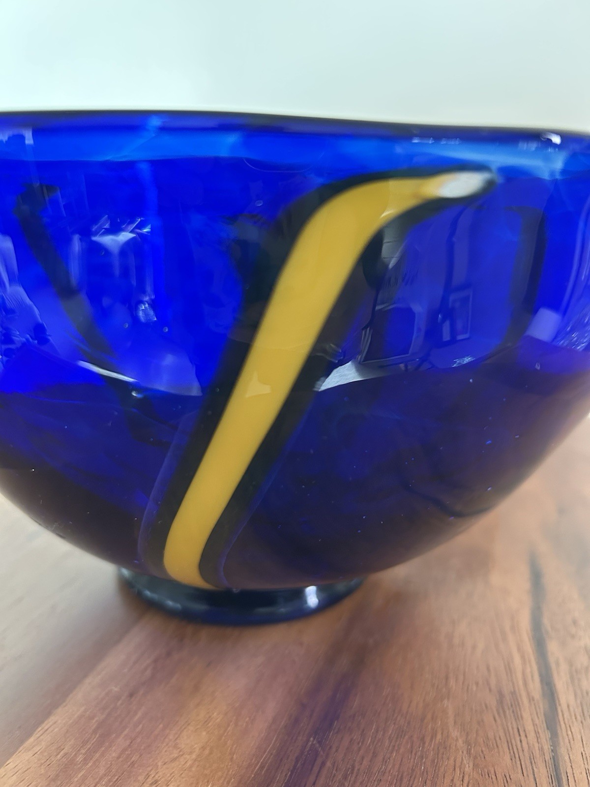 Cobalt blue art glass bowl with yellow and white design